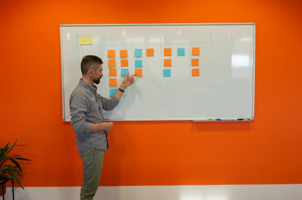 Arquitecto organizando un plan con notas en la pizarra